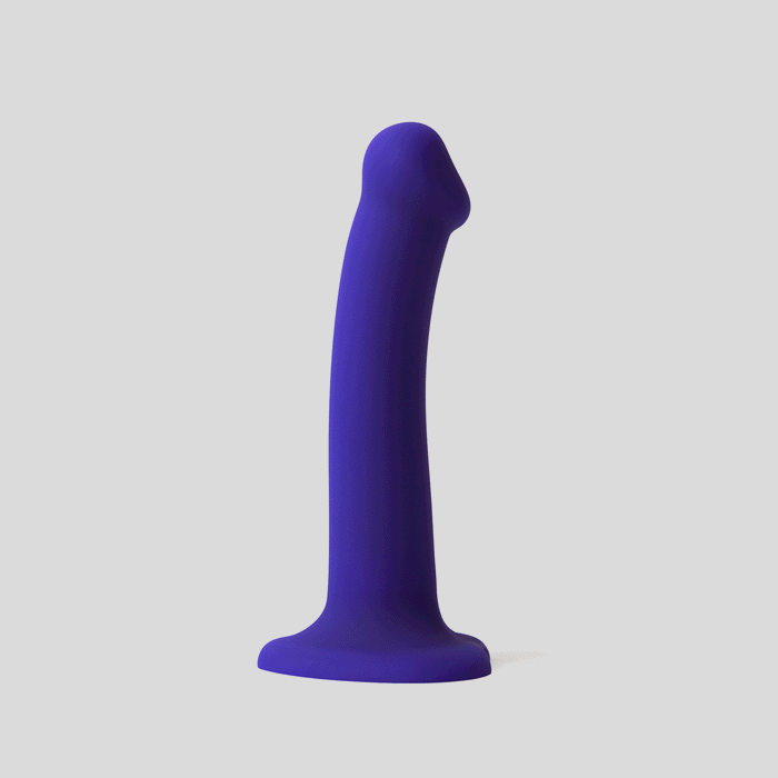 A blue silicone dildo with LED lights, flared base, and strap-on harness compatibility stands upright against a plain light gray background.