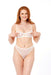 A woman with long red hair smiles while wearing a sheer white lingerie set, accessorized with Peaches 'n Cream Pearl Nipple Clamps, standing against a white background.