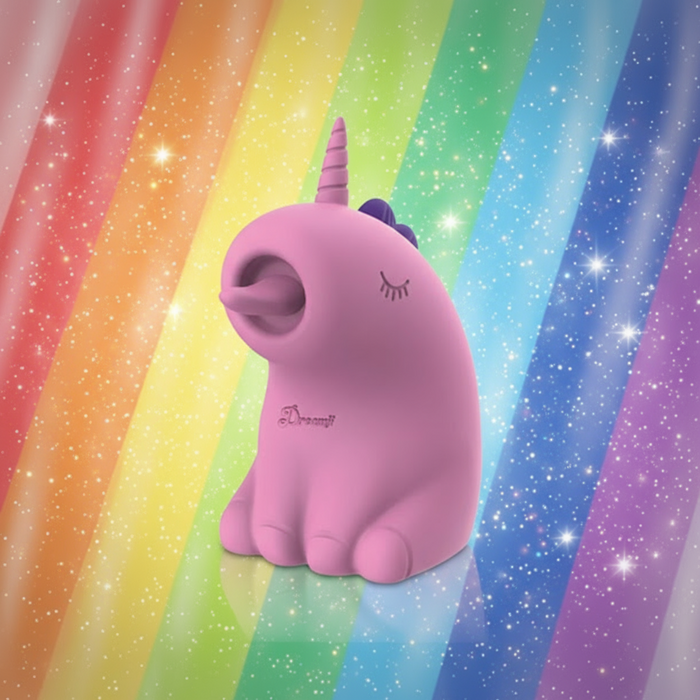 The Dreamy Licks – Whimsical Unicorn Tongue Vibrator, made of body-safe silicone with a purple mane and single horn, sits against a sparkling rainbow background, its playful charm reflected in closed eyes and an open mouth.