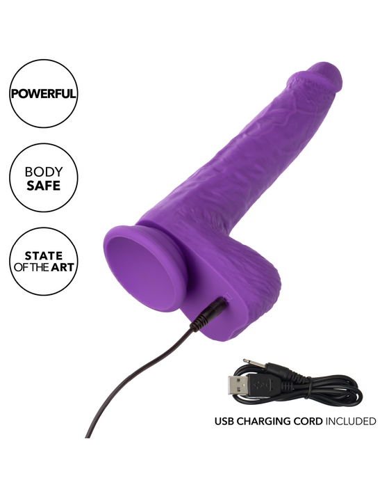 A CalExotics Silicone Stud Gyrating & Thrusting 9.5 Inch Purple Dildo with a realistic design shown upright with a USB charging cord plugged into its base. Text on the image highlights features: "Powerful," "Body Safe," and "State of the Art." Crafted from silky silicone, it comes with an extra USB charging cord displayed at the bottom.
