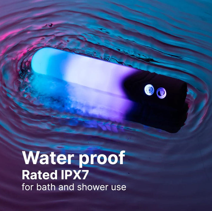 White LED bullet vibrator glowing blue and purple, partially submerged in water.