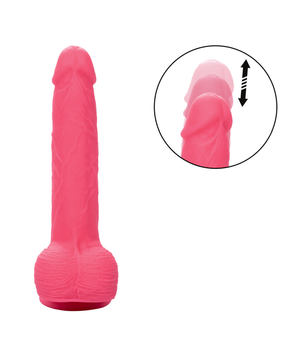 A pink, silky Silicone Stud Rumbling & Thrusting 9.5 Inch Pink Dildo from CalExotics with a realistic texture stands upright against a white background. A circular inset in the top right corner illustrates the vibrating dildo's ability to expand or move with an up-and-down motion indicated by an arrow.