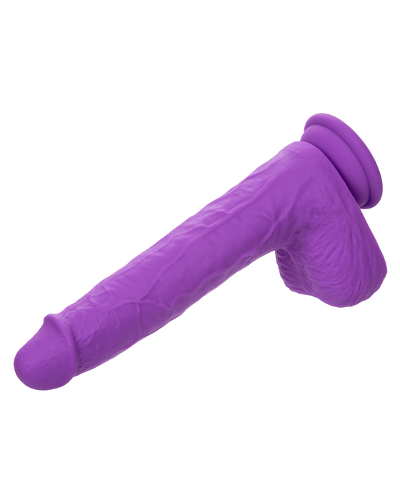 A CalExotics Silicone Stud Gyrating & Thrusting 9.5 Inch Purple Dildo made of silky silicone features realistic detailing, a pronounced head, veined shaft, and a compact base. The base is a suction cup. Positioned horizontally against a white background, this toy promises intense action.