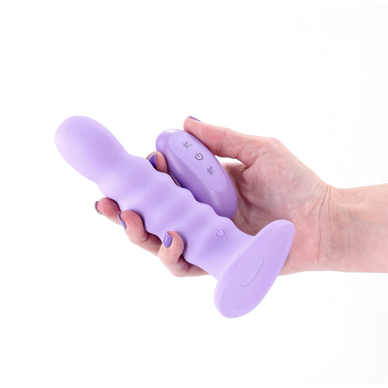 Hand holding a 6-inch ribbed purple silicone vibrating dildo with a remote control.