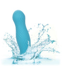 A blue Wave Rider Swell Short, Girthy 5 Inch Liquid Silicone Dildo with a wavy texture creating a dynamic splash in clear water, depicted against a white background, featuring a suction cup by CalExotics.