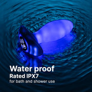 White, waterproof butt plug with a flared base, glowing blue in rippling dark water.