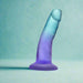 The Morning Dew Small 5 Inch Dildo with Suction Cup - Blue, a translucent gradient blue and purple dildo with a flared base, stands upright on a light teal surface. It's beginner-friendly, suction-based, and harness compatible for versatile play.