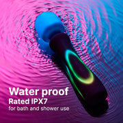 Illumination Wand LED vibrator, black handle with glowing green ring, blue massage head, in rippling pink and blue water.