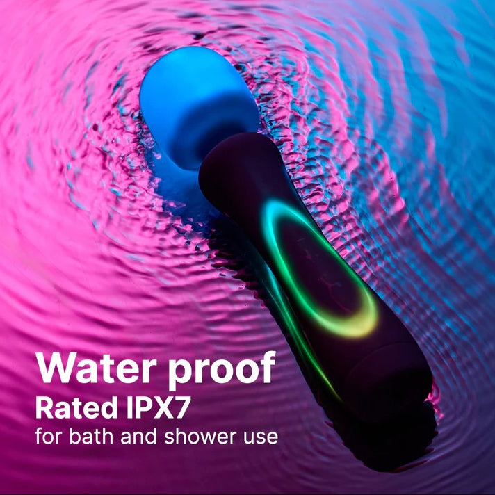 Illumination Wand LED vibrator, black handle with glowing green ring, blue massage head, in rippling pink and blue water.