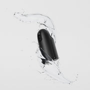The Arcwave Ion 2 Penis Masturbator with Pleasure Air Suction, shown in sleek black amid splashing water on a light gray background, highlights its water-resistant design and innovative Pleasure Air technology.