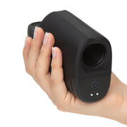 A hand holding the Arcwave Ion 2 Penis Masturbator with Pleasure Air Suction, a black, rectangular male stroker featuring an open ribbed end and side buttons with indicator lights for innovative stimulation.