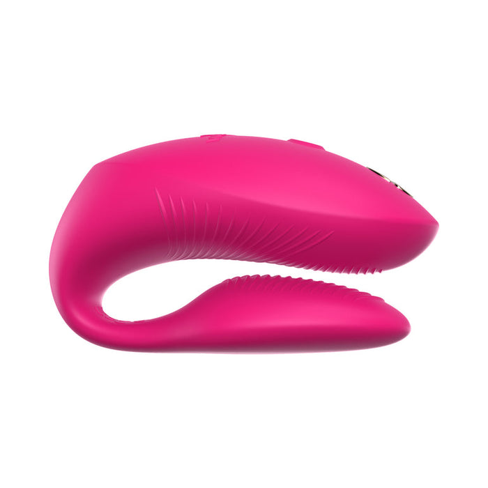 The We-Vibe Chorus Pro Wearable Couples' Vibrator, shown in pink silicone with a curved shape and textured inner surface, features triple motors and Fusion Wave Technology for enhanced G-spot stimulation, displayed against a white background.