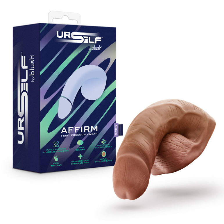 The URSELF 5 Inch Chocolate Silicone Packer Dildo is shown next to its box, labeled "URSELF by Blush" and "AFFIRM." Made from body-safe platinum-cured silicone, the packaging has a blue and green abstract design with icons and text.