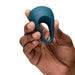 A hand holds the blue We-Vibe Pivot 2 Vibrating Silicone Rechargeable Penis Ring, with "we-vibe" branding visible against a white background.