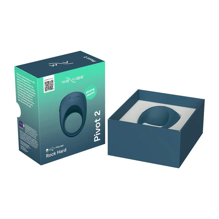 A teal We-Vibe Pivot 2 Vibrating Silicone Rechargeable Penis Ring rests in a blue open box beside packaging highlighting the brand, product name, and features like hands-free clitoral stimulation and strong vibrations.