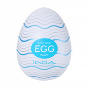 A white, egg-shaped male masturbator with wavy blue lines, featuring a textured sleeve for heightened pleasure. Sold as the "Tenga Egg Standard 3 Pack Disposable Masturbators I," with branding on the front.