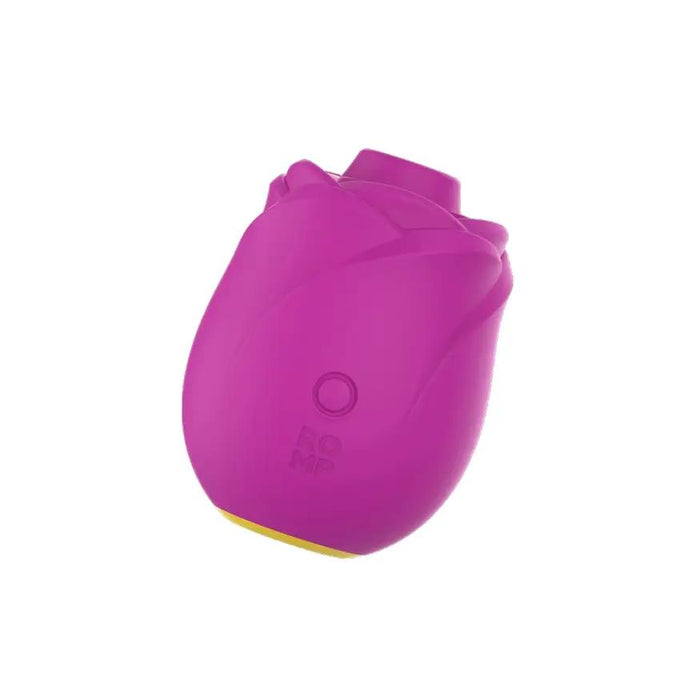 The Romp Rose 2 Pleasure Air Clitoris Stimulator in pink is a small, rose-shaped rechargeable silicone toy with petal-like details, a yellow base, button control, and "ROMP" on the front, designed for clitoral stimulation.