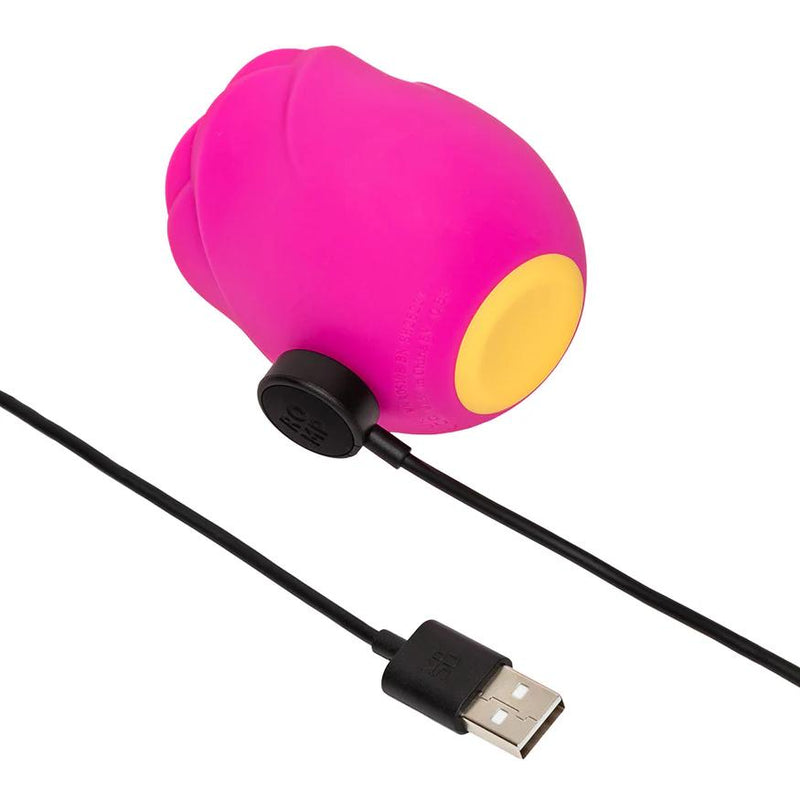 The Romp Rose 2 Pleasure Air Clitoris Stimulator in pink features a rose-shaped silicone design with a yellow base and is rechargeable via a black USB cable.