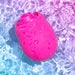 The Romp Rose 2 Pleasure Air Clitoris Stimulator in pink, shaped like a rose with water droplets, floats in clear blue and purple water reflecting shimmering light.