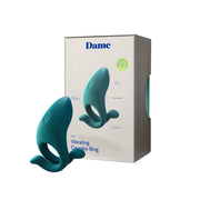A teal, whale-shaped Dame Hug Adjustable Vibrating Cock Ring for Couples sits in front of its packaging, with listed features for this adjustable penis ring shown on the side.