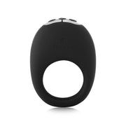 The Je Joue Mio Vibrating Cock Ring - Black is an oval-shaped, black silicone ring with a circular bottom opening, simple top button controls, and the elegant Je Joue Mio logo embossed on the front.