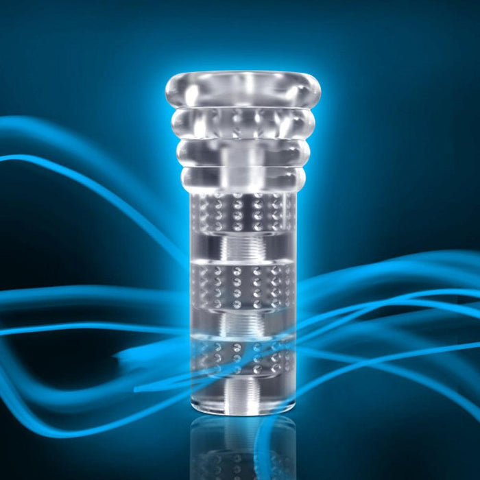 A futuristic, transparent cylindrical object with intricate internal structures, highlighted against a vibrant blue background with dynamic swirling blue light trails. The "All Nighter Glow in the Dark Textured Clear Self Lubricating Stroker" by Blush features a discreet, metallic-hued design with multiple segmented sections and textured surfaces.