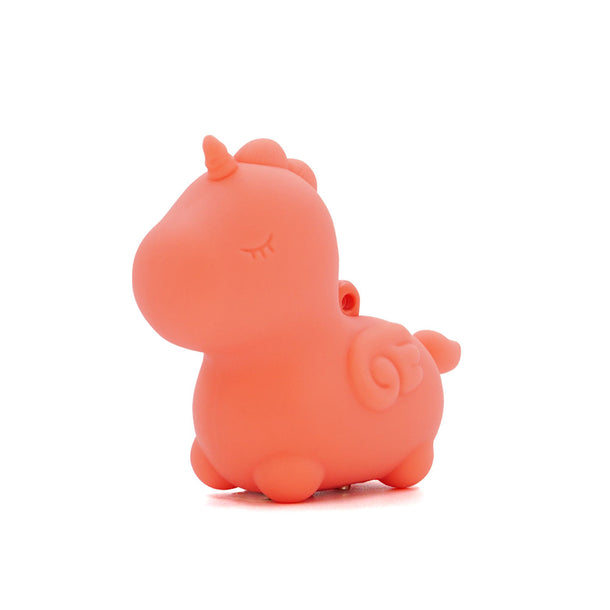 The Unihorn Mini - Peachy Pony Discreet Vibrator is a small, peach-colored unicorn figurine made of body-safe silicone, with a rounded body, closed eyes, short horn, and swirled tail, shown against a white background.