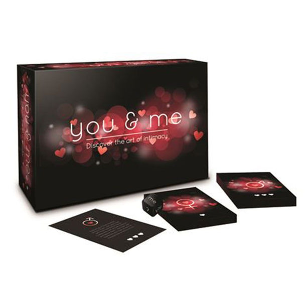 You and Me - A Game of Love & Intimacy" is shown with a black and red box, two decks of cards, a black die, and instructions—an ideal couples game for date night—all arranged on a white background.