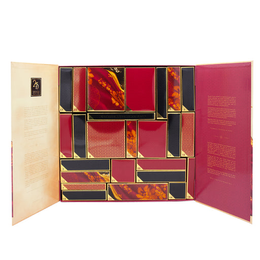 The Shunga Advent Calendar of Desires features 25 days of luxury, pleasure, and passion in a geometric box with red, black, and gold compartments. Gold text and elegant designs inside create an unforgettable sensual gift set.