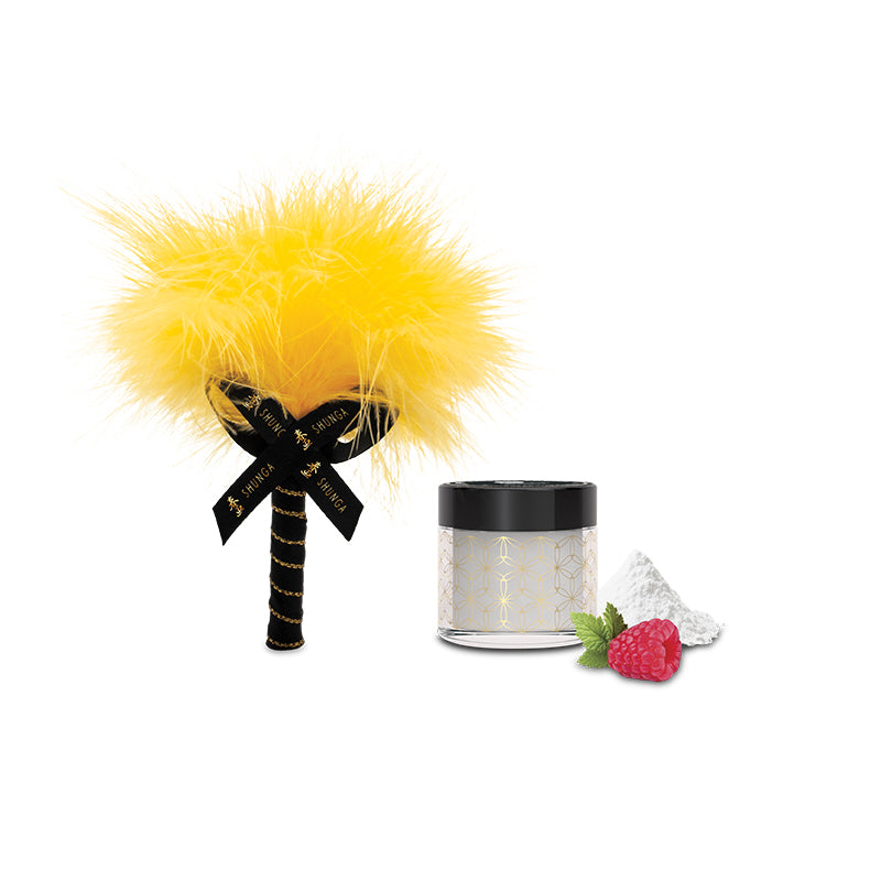 A yellow feather tickler with a black ribbon sits beside a small jar of white powder garnished with a raspberry and mint leaves—all from the Shunga Advent Calendar of Desires – 25 Days of Luxury, Pleasure & Passion.