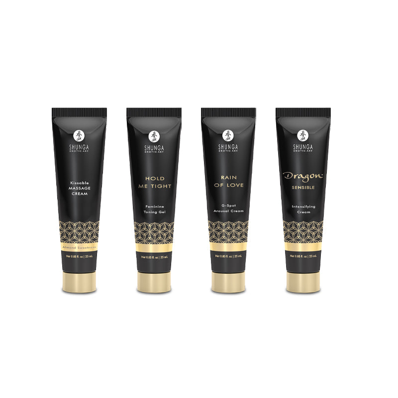 Four black and gold tubes from the Shunga Advent Calendar of Desires – 25 Days of Luxury, Pleasure & Passion are displayed on a white background, featuring Kissable Massage Cream, Hold Me Tight Gel, Rain of Love G-Spot Cream, and Dragon Sensible Cream.