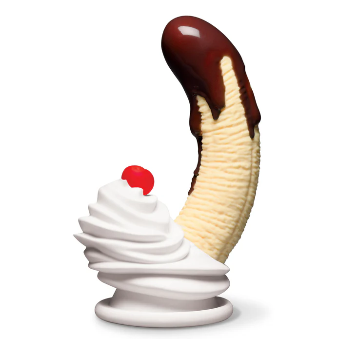 The Chocolate Dipped Banana Split Silicone Dildo with Suction Cup stands upright, styled like a chocolate-covered banana with whipped cream and a cherry on top, all crafted from body-safe silicone against a white background.