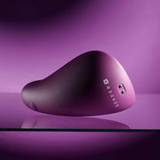 Smooth, compact purple silicone vibrator with "GENDER X" logo and two silver control buttons.