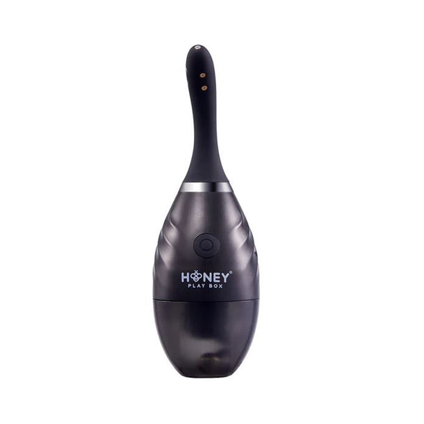 The Bulby Auto Spray Anal Douche System by Honey Play Box is a black, oval-shaped device with a curved handle and USB rechargeability, offering convenient, portable cleaning. The "Honey Play Box" logo appears on its base against a white background.