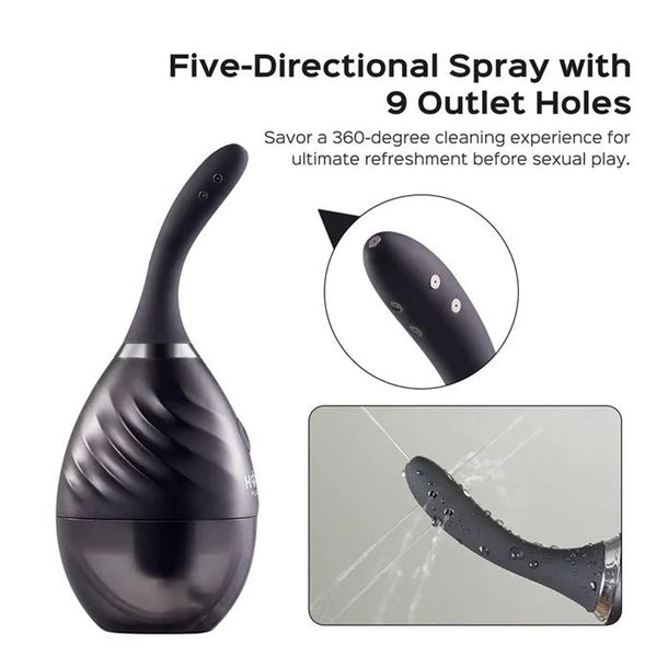 The Bulby Auto Spray Anal Douche System by Honey Play Box is a black, curved, USB-rechargeable device with 9 spray holes. Shown spraying from its tip, it features five-directional jets for thorough 360° cleaning.
