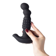 A hand with painted nails holds the Pineapple Man Rolling Bead Prostate Vibrator with App Control, a black curved anal toy featuring rolling beads, a textured grip, and bulbous tip, against a white background.