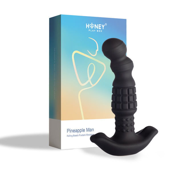 A black textured Pineapple Man Rolling Bead Prostate Vibrator with app control stands before a colorful "Honey Play Box" package featuring a minimalist line drawing on a gradient background.