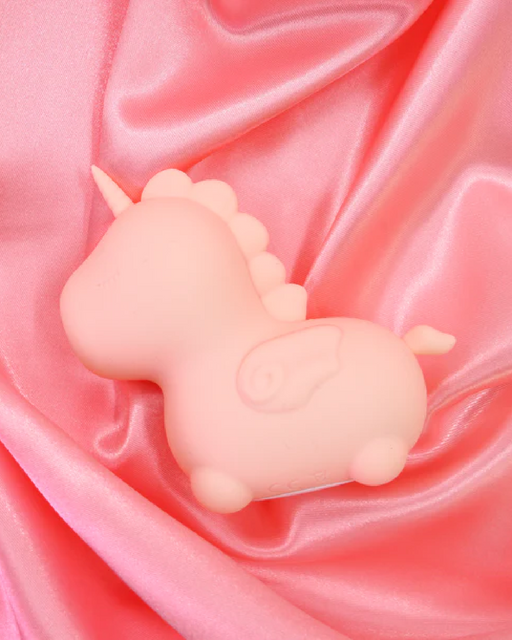 Heart Throb Unicorn Shaped Clitoral Pulsating Vibrator - Orange on satiny blanket