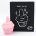The Cake Eater Clitoral Stimulator Tongue Vibrator in pink, shaped like a cupcake, is displayed next to a black box with a white cupcake illustration and the words "Cake Eater" and "Toy Natalie's Box.