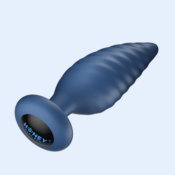 The Noah App-Enabled Rotating Butt Plug is a blue, textured silicone anal toy with a spiral design and flared base displaying "HONEY" with a bee graphic, shown against a light background.