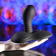 A realistic white mannequin hand displays the Playboy Sittin' & Spinnin' Hands Free G-Spot Vibrating Grinder Pad against a vibrant, colorful abstract background.