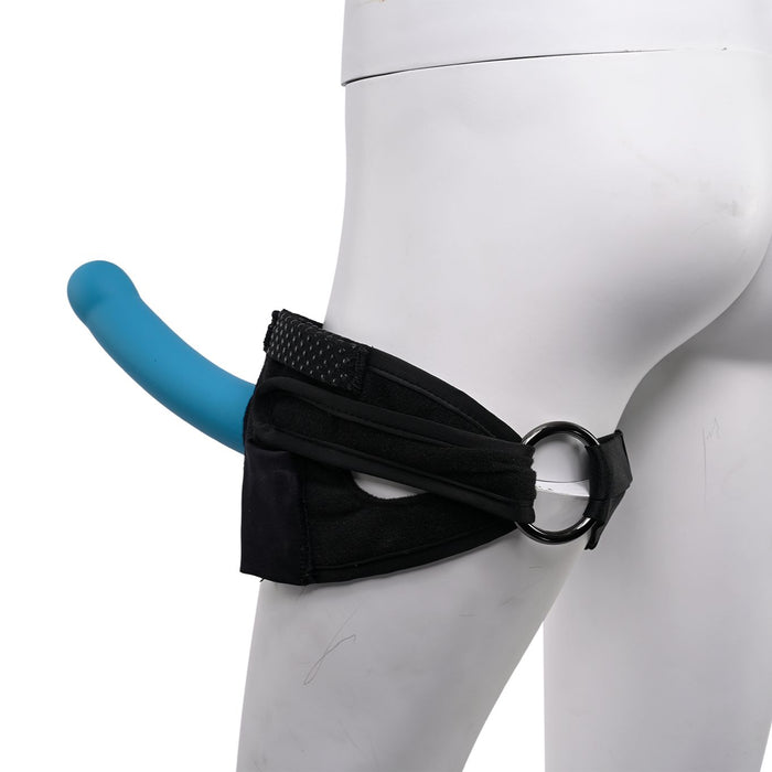 A close-up of a mannequin's lower body showcases the Pivot Forced Orgasm and Thigh Mount Strap-on Harness by Sportsheets, featuring a black thigh harness with a blue dildo attached. This partner thigh harness straps around the thigh, including adjustable bands and metal rings for a secure fit. The dildo is positioned outward from the harness.