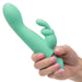 A hand with pink painted nails holds the Love Bunny Rockin’ G Triple Motor Rabbit Vibrator in mint green against a white background.
