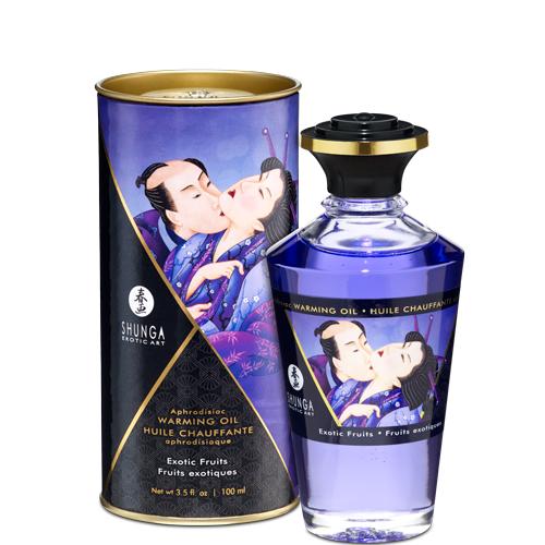 A bottle of Aphrodisiac Cherry Warming Oil for Erogenous Zones 100 ml sits before its cylindrical packaging, both featuring romantic Japanese art in purple and gold and labeled "Exotic Fruits.