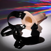 The Our First Hollow Strap-On Dildo + Harness Set - Vanilla, shown on a white surface with rainbow reflections, is ideal as a hollow strap-on dildo for people experiencing erectile dysfunction.