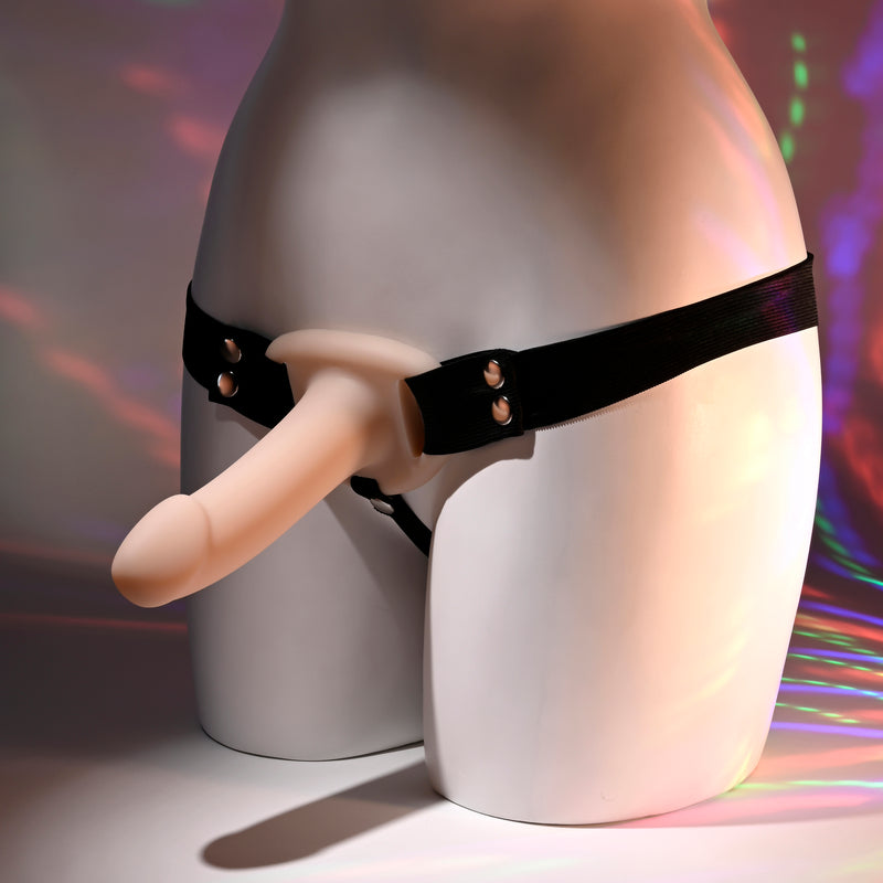 A mannequin torso displays the Our First Hollow Strap-On Dildo + Harness Set - Vanilla, featuring a realistic, skin-toned dildo against a rainbow background—perfect for those with ED or beginners seeking a strap-on harness.