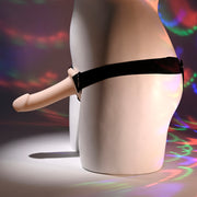 A white mannequin’s lower torso wears the Our First Hollow Strap-On Dildo + Harness Set - Vanilla. Colorful, circular light patterns shine on the mannequin and background. Great for beginners or those exploring strap-on play and ED solutions.