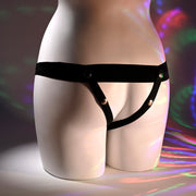 A mannequin torso is shown from behind, wearing the Our First Hollow Strap-On Dildo + Harness Set - Vanilla. Colorful circular light patterns are projected onto the background and lower half of the mannequin.