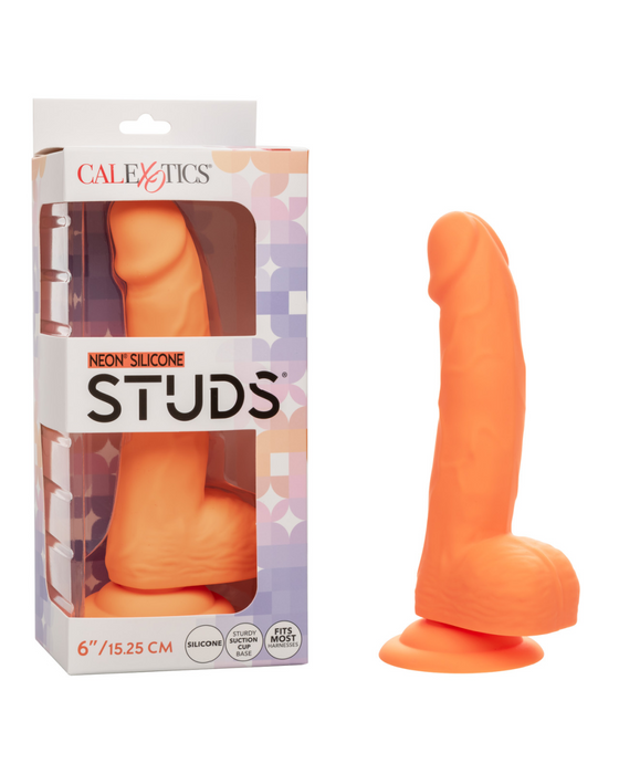 A bright neon-hued delight, this orange silicone dildo features a powerful suction cup base and comes beside its packaging. The package displays the product name "Silicone Stud 8 Inch Suction Cup Dildo - Orange" and its size, 6 inches (15.25 cm). The dildo has a realistic design crafted from high-quality silicone material by CalExotics.