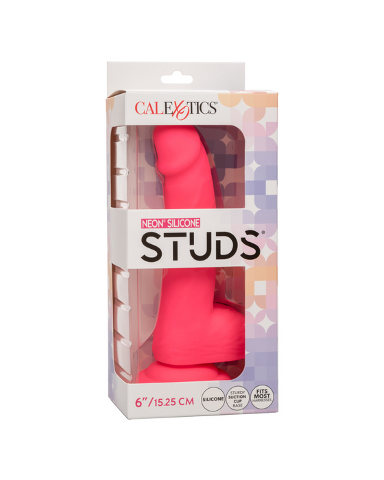 A retail box containing a pink Silicone Stud 8 Inch Suction Cup Dildo from CalExotics. The packaging is white with colorful geometric patterns and text indicating the product is a neon-hued delight, 8 inches (20.32 cm), made from body safe silicone, and has a powerful suction cup base.